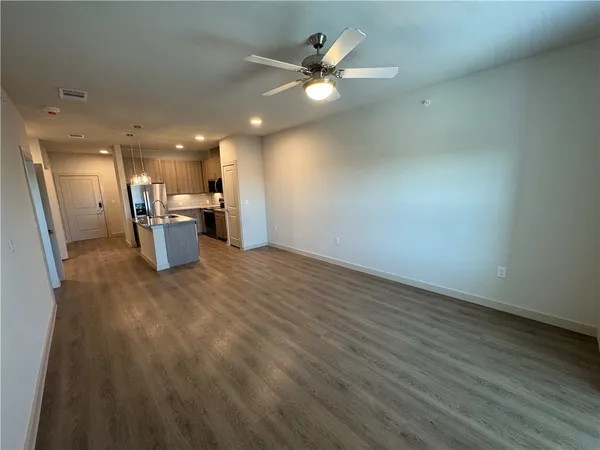 an empty room with windows and fan