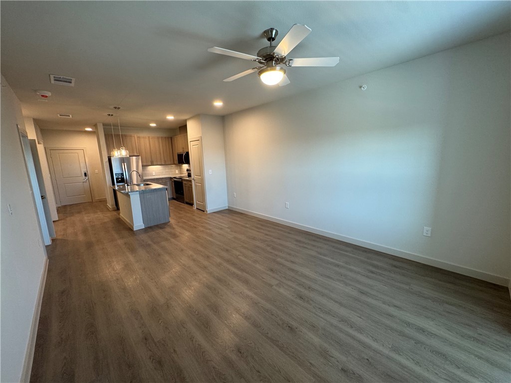 6000 Jones Road, Unit 4202 Bryan, TX 77807 - Photo 8 of 19 an empty room with wooden floor and a ceiling fan