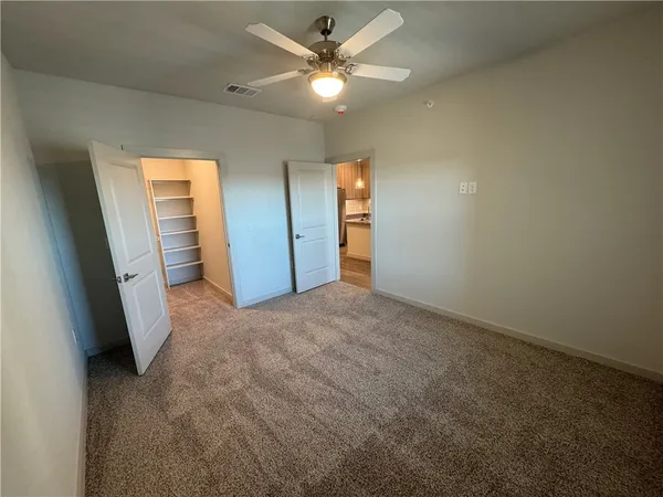 a view of walk in closet with empty racks
