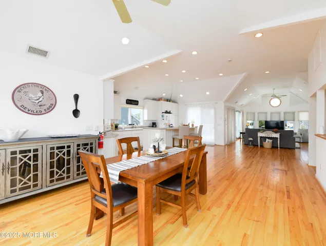 a dining room with stainless steel appliances kitchen island granite countertop a dining table chairs and view living room