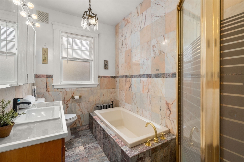 21 Colbourne Crescent, Unit 1 Brookline, MA 02445 - Photo 25 of 35 a bathroom with a tub sink and mirror