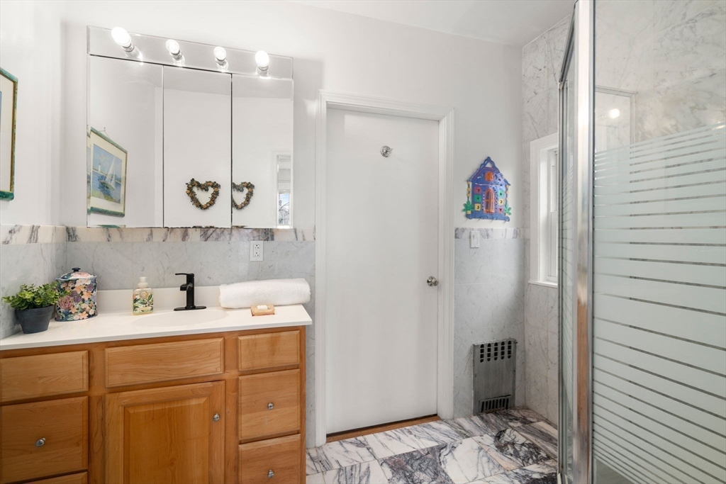 21 Colbourne Crescent, Unit 1 Brookline, MA 02445 - Photo 26 of 35 a bathroom with a sink a mirror and shower