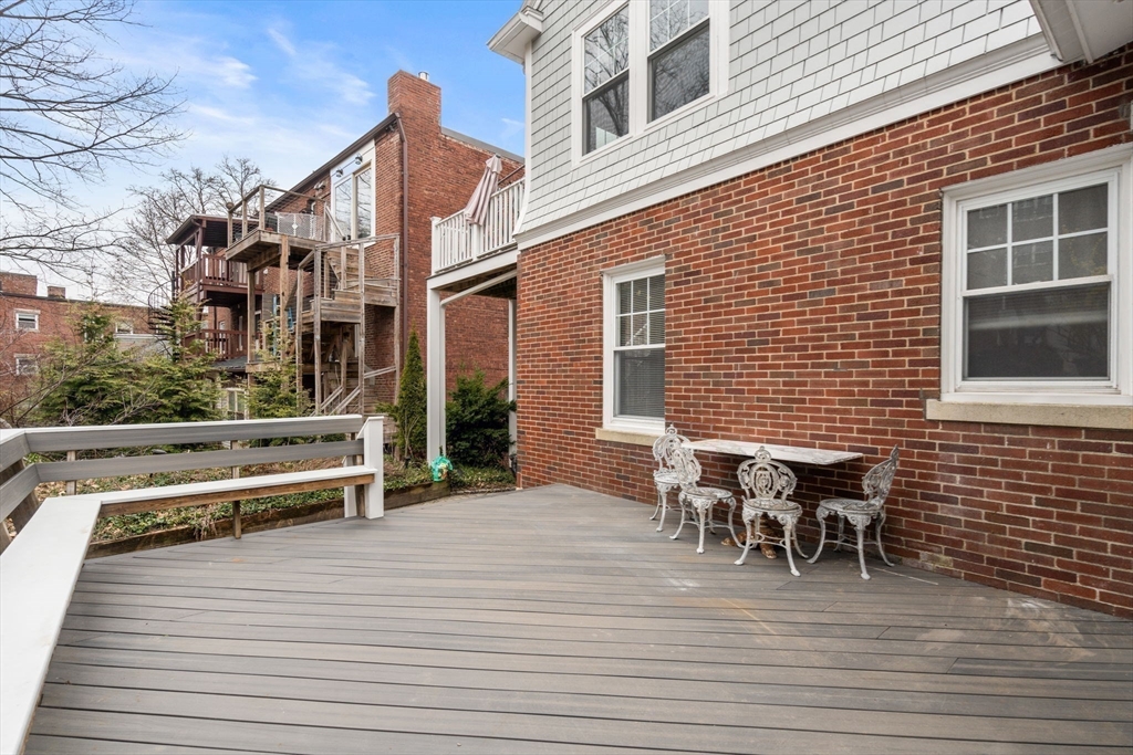 21 Colbourne Crescent, Unit 1 Brookline, MA 02445 - Photo 30 of 35 a view of a roof deck with table and chairs with wooden floor and fence