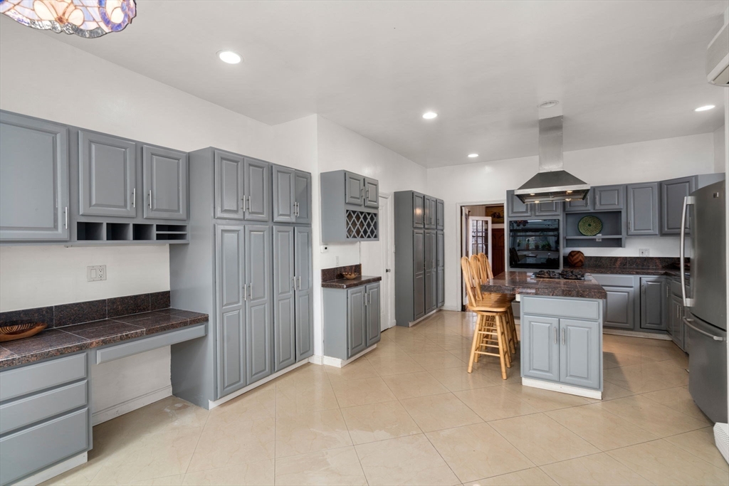 21 Colbourne Crescent, Unit 1 Brookline, MA 02445 - Photo 7 of 35 a kitchen with kitchen island granite countertop lots of counter top space and stainless steel appliances