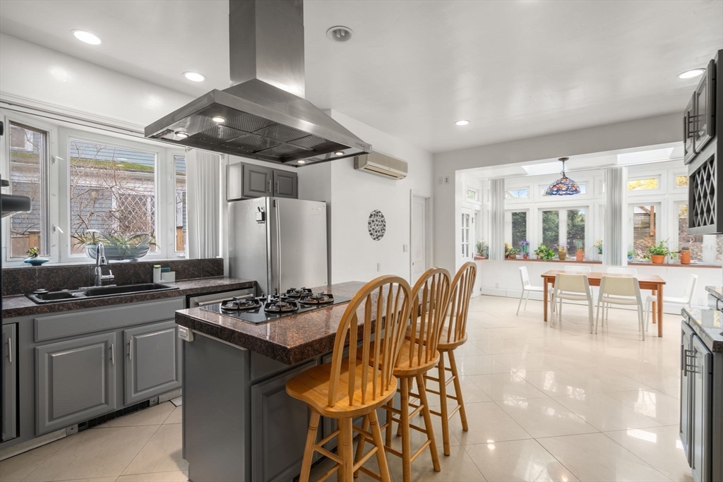 21 Colbourne Crescent, Unit 1 Brookline, MA 02445 - Photo 8 of 35 a kitchen with stainless steel appliances kitchen island granite countertop a stove a sink and a refrigerator