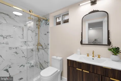 a bathroom with a sink vanity mirror and toilet