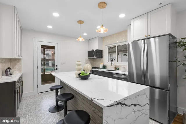 a kitchen with refrigerator and chairs