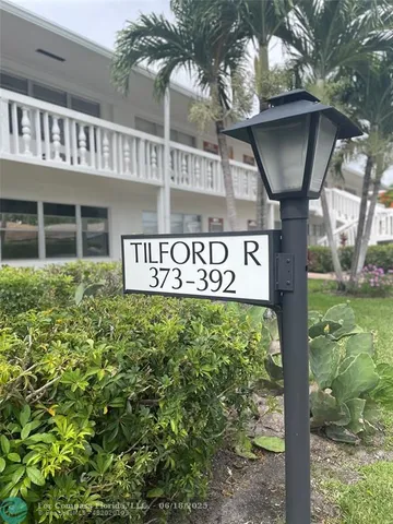 a sign broad in front of a brick house