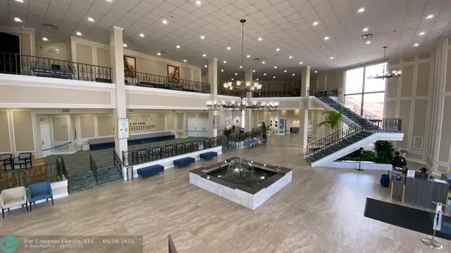 a view of a dining hall with lots of tables a large window and furniture