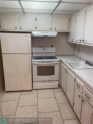 a kitchen with appliances cabinets and a sink