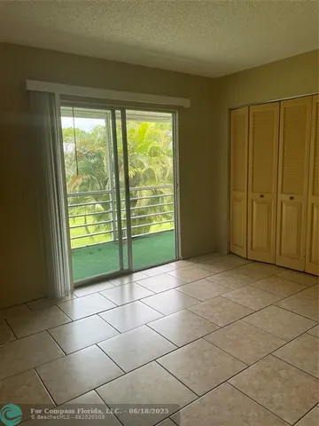 a view of an empty room with a sink and a window