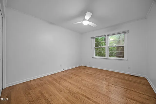 wooden floor in an empty room with a window