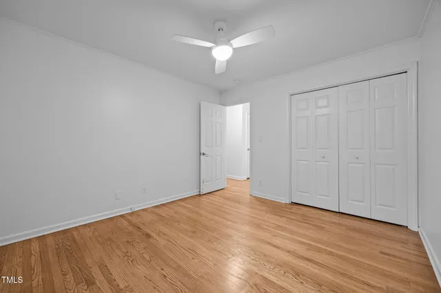 a view of an empty room with wooden floor