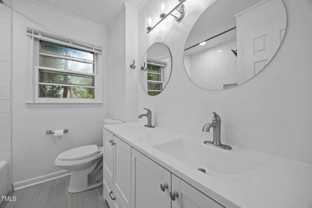 a bathroom with a toilet a sink and mirror