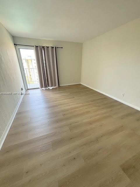 4550 Northwest 9th Street, Unit 803E Miami, FL 33126 - Photo 12 of 31 an empty room with wooden floor and windows