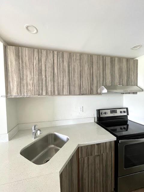 4550 Northwest 9th Street, Unit 803E Miami, FL 33126 - Photo 6 of 31 a kitchen with a sink a stove and cabinets