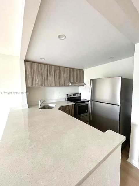 4550 Northwest 9th Street, Unit 803E Miami, FL 33126 - Photo 7 of 31 a kitchen with stainless steel appliances a refrigerator sink and cabinets