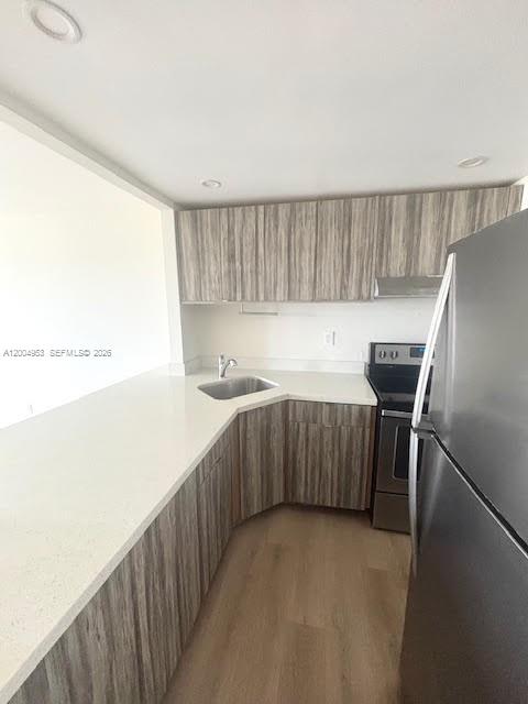 4550 Northwest 9th Street, Unit 803E Miami, FL 33126 - Photo 8 of 31 a kitchen with a sink a refrigerator and wooden floor
