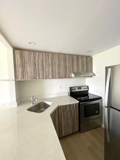4550 Northwest 9th Street, Unit 803E Miami, FL 33126 - Photo 9 of 31 a kitchen with stainless steel appliances a stove a sink a refrigerator and cabinets