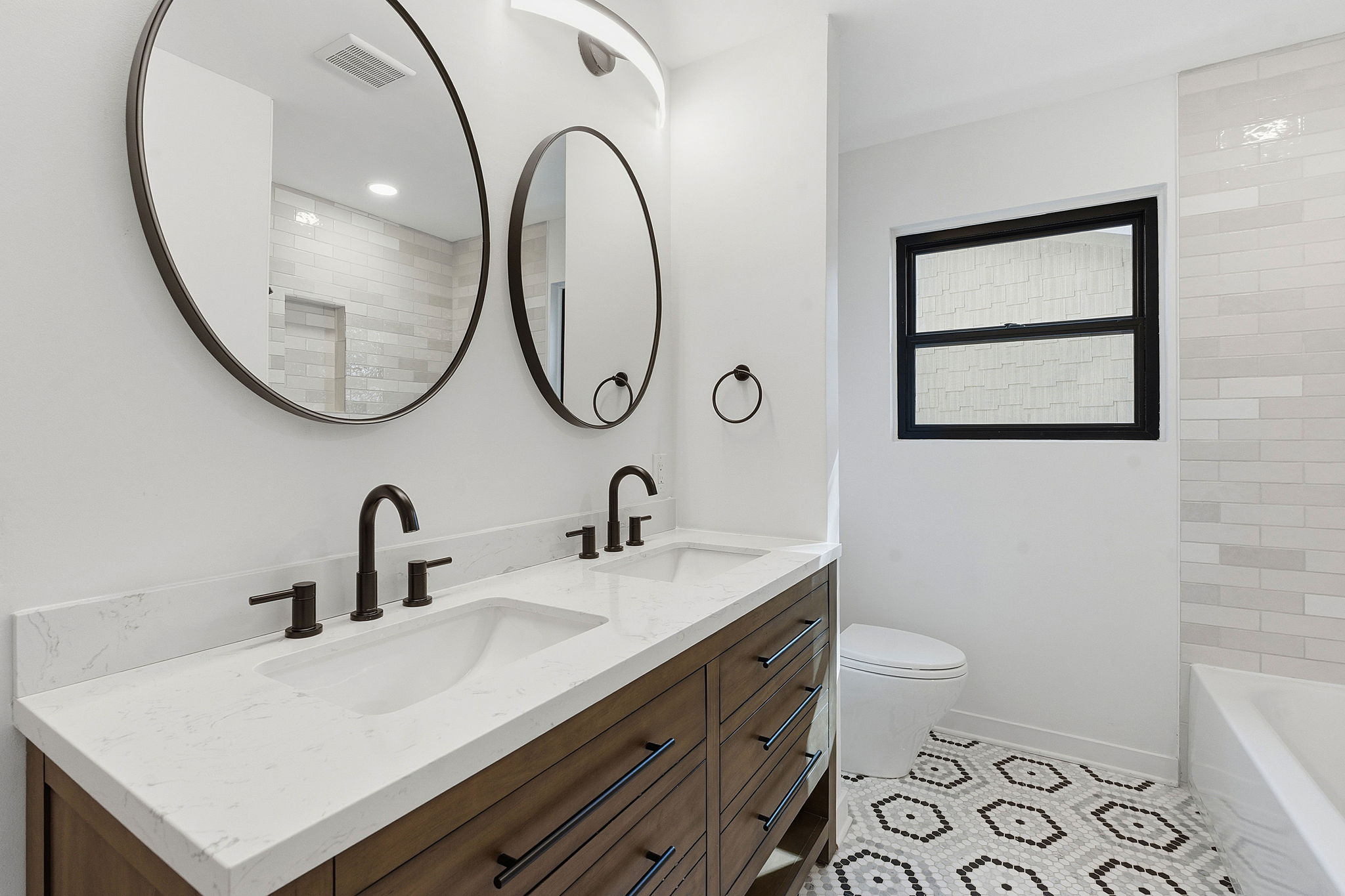 5609 Mapleleaf Drive Austin, TX 78723 - Photo 16 of 19 Bathroom with double vanity, light tile patterned floors, tub / shower combination, and recessed lighting
