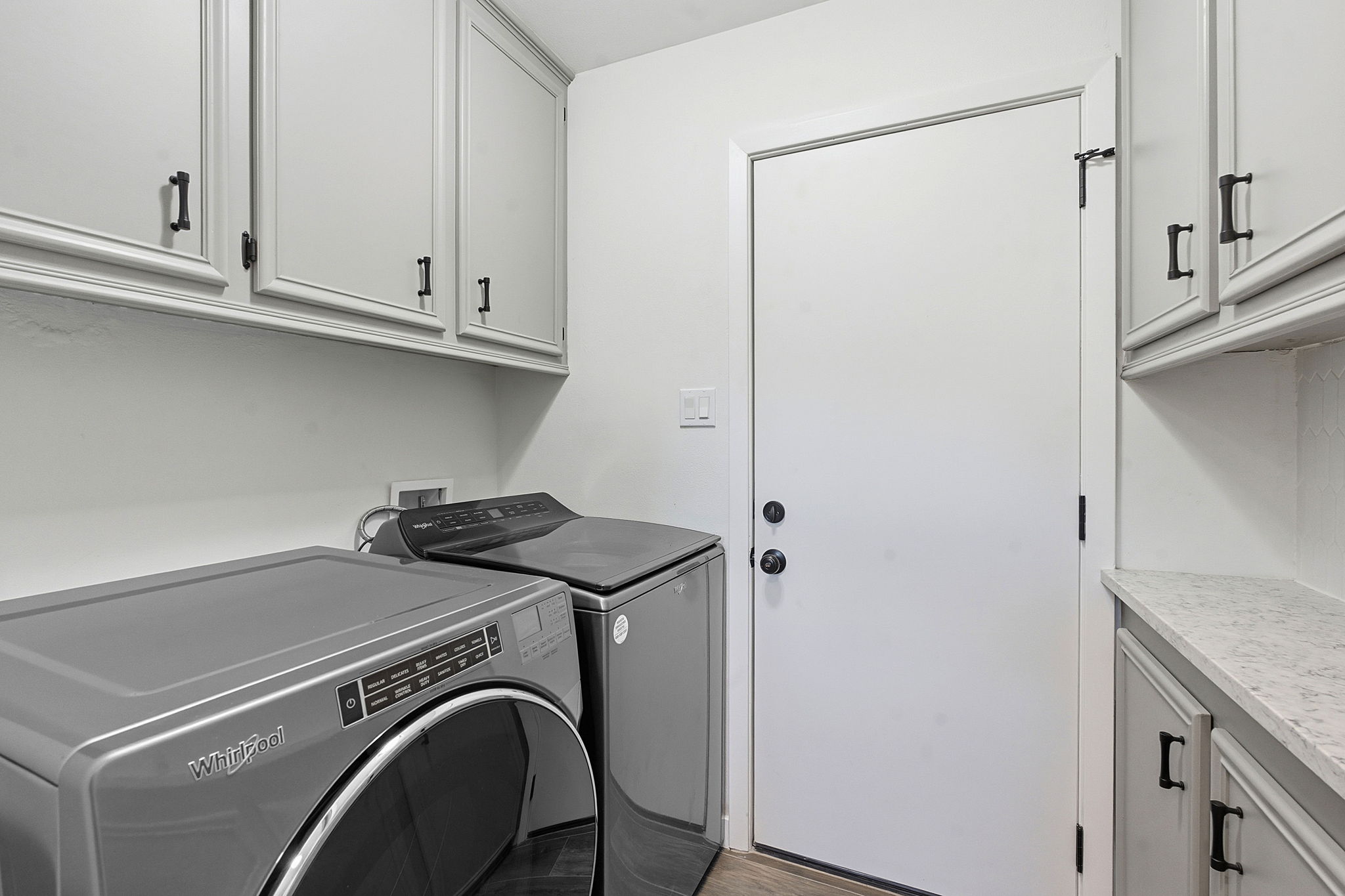 5609 Mapleleaf Drive Austin, TX 78723 - Photo 17 of 19 Laundry room featuring cabinet space, light wood finished floors, and washing machine and clothes dryer