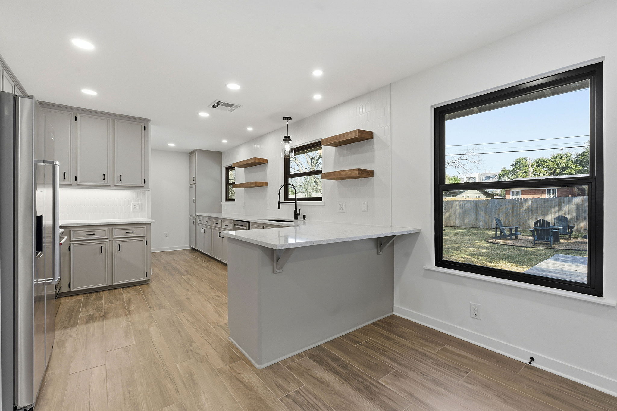 5609 Mapleleaf Drive Austin, TX 78723 - Photo 5 of 19 Kitchen with open shelves, gray cabinets, a peninsula, wood finish floors, and recessed lighting