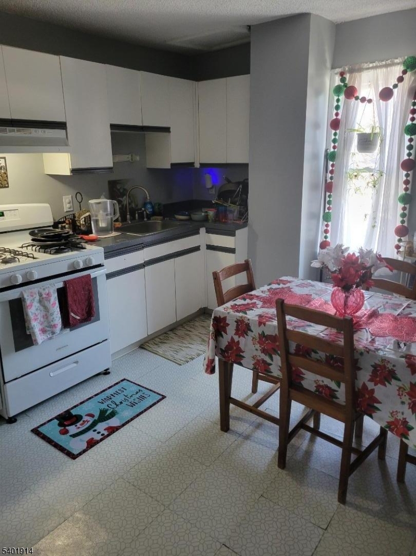 425 Main Street West Orange, NJ 07052 - Photo 9 of 20 a kitchen with a table chairs and a stove
