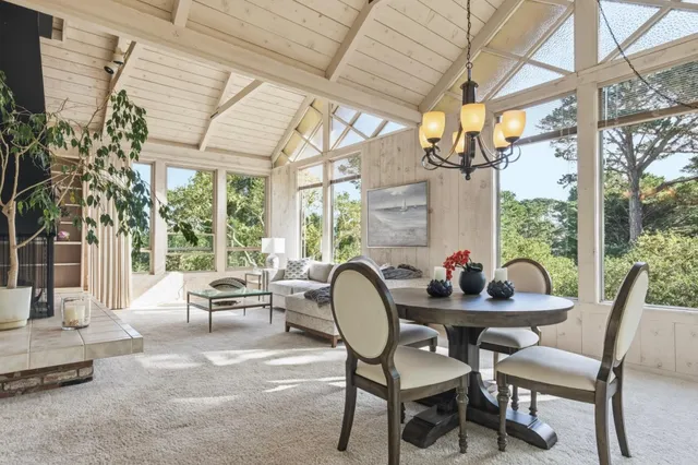 a dining room with furniture a chandelier and wooden floor