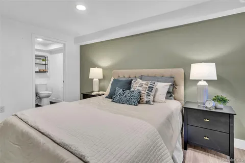 a bedroom with a bed and a lamp on dresser