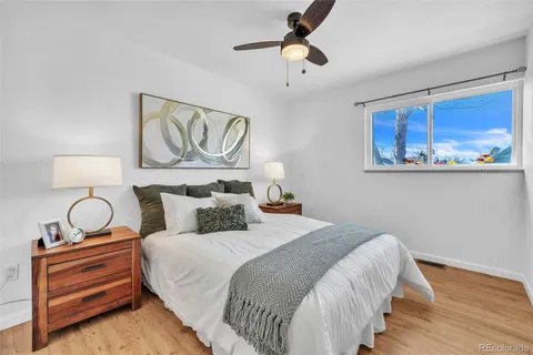 a bedroom with bed and wooden floor