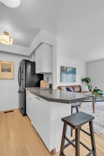 a kitchen with stainless steel appliances granite countertop a sink refrigerator and cabinets