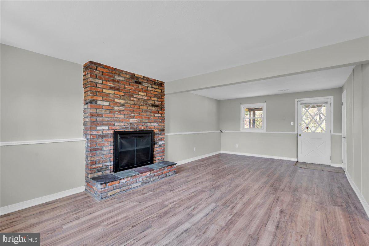 301 County House Road Sewell, NJ 08080 - Photo 15 of 23 an empty room with wooden floor fireplace and windows