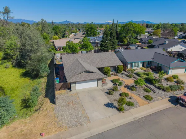 an aerial view of a house with a garden and lake view