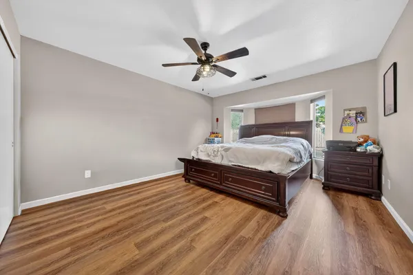 a bedroom with a bed and wooden floor