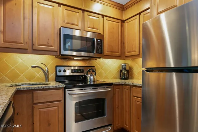 a kitchen with stainless steel appliances granite countertop a refrigerator stove and microwave
