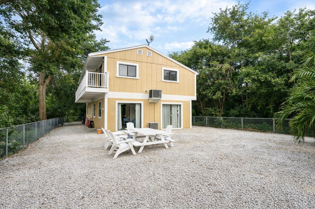 335 Bayview Avenue Key Largo, FL 33037 - Photo 23 of 57 a white house with a large tree and wooden fence