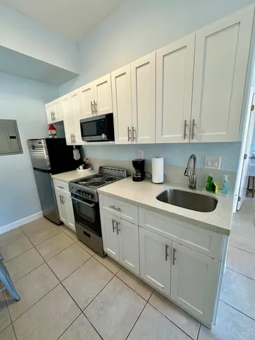 a kitchen with a sink a stove and a microwave