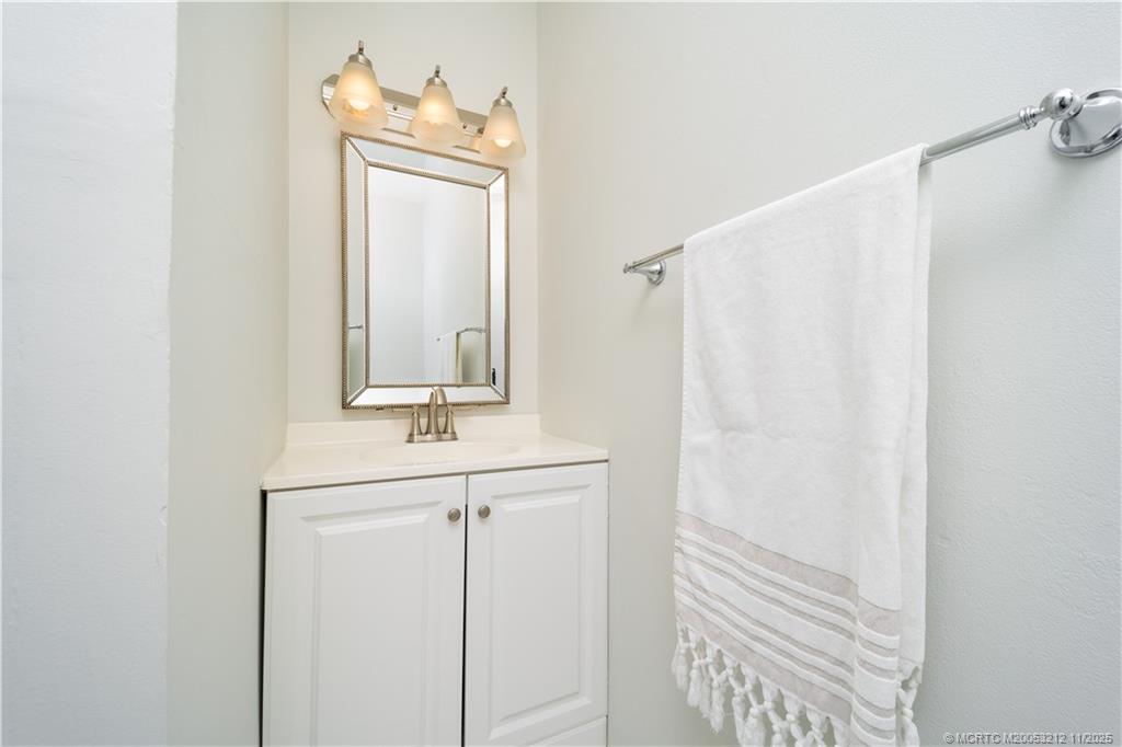 2929 Southeast Ocean Boulevard, Unit K1 Stuart, FL 34996 - Photo 11 of 26 a bathroom with a sink a mirror and a window