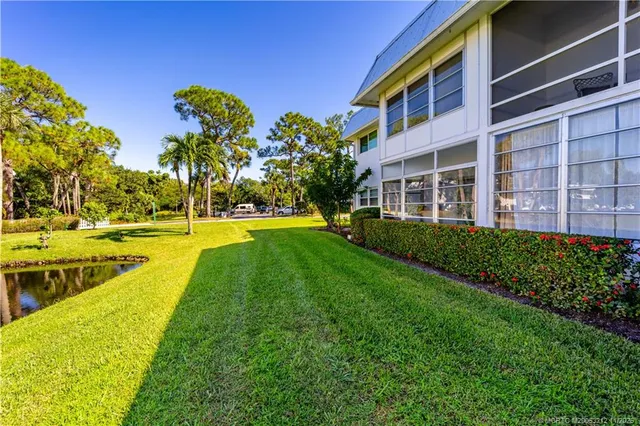 a view of a house with a yard and potted plants