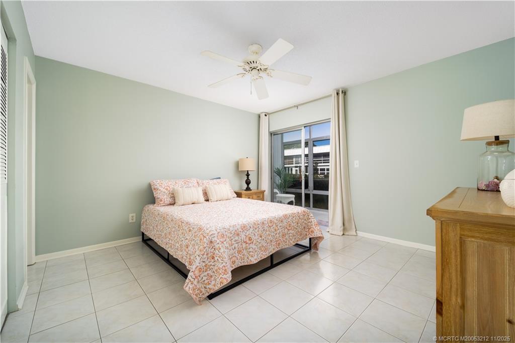 2929 Southeast Ocean Boulevard, Unit K1 Stuart, FL 34996 - Photo 9 of 26 a bedroom with a bed and a chandelier