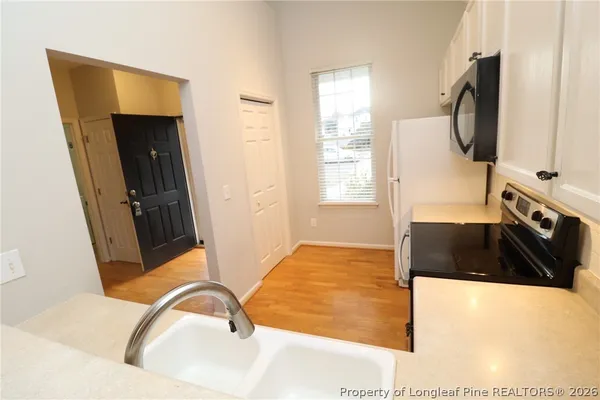 a kitchen with a sink stove and microwave