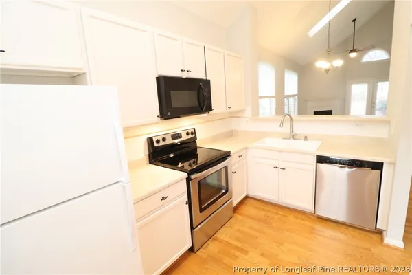 a kitchen with stainless steel appliances a stove microwave and sink