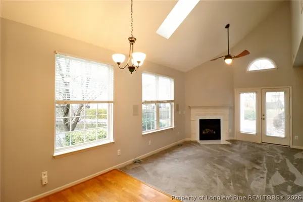 a view of an empty room with window and fire place