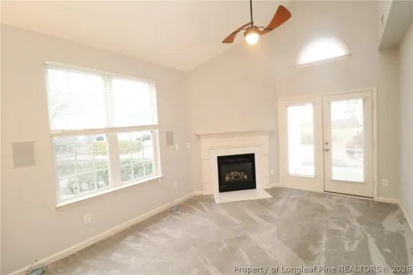 a view of empty room with a fireplace and windows