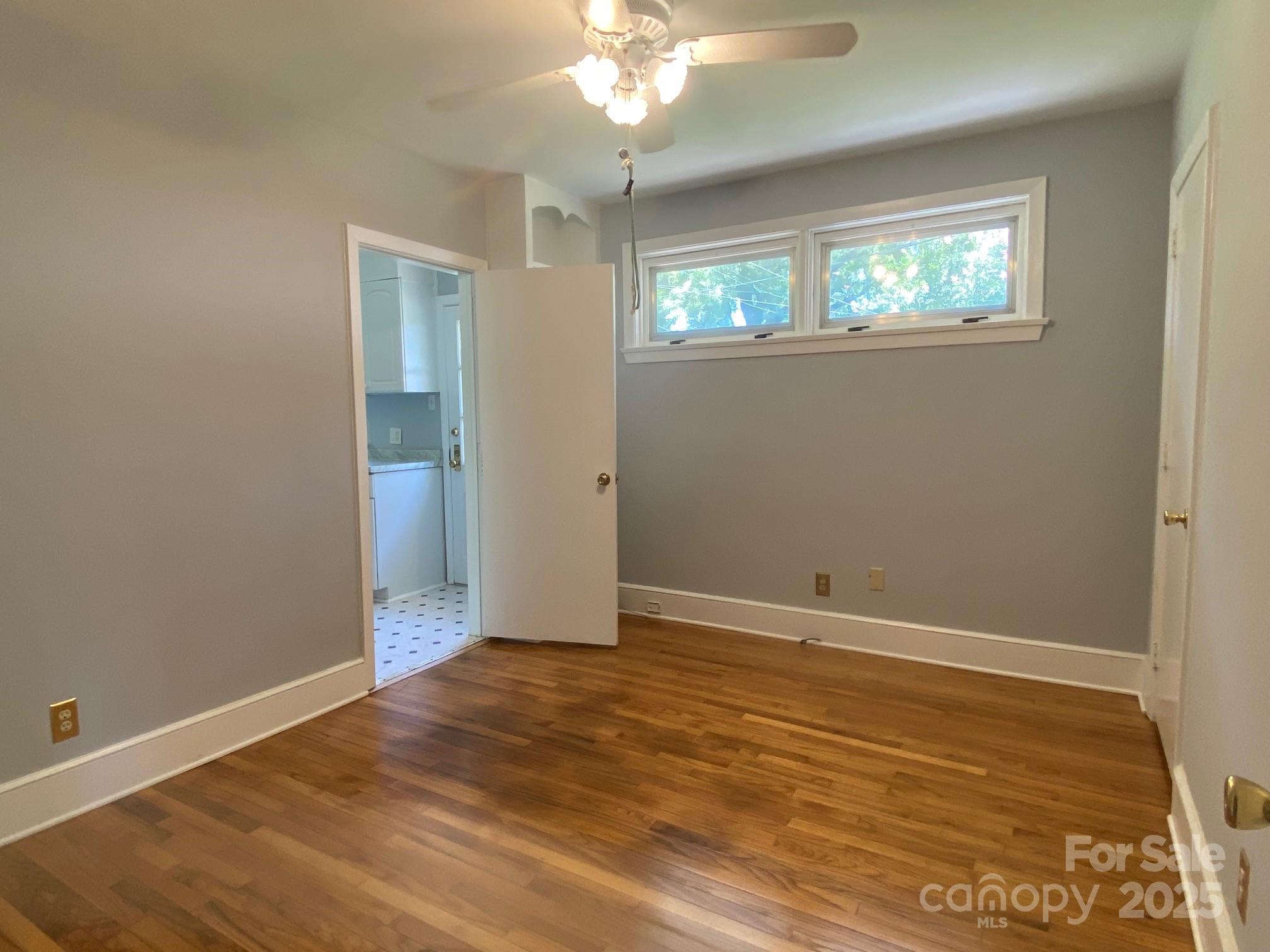 1017 Andover Road Charlotte, NC 28211 - Photo 15 of 20 an empty room with wooden floor cabinet and windows