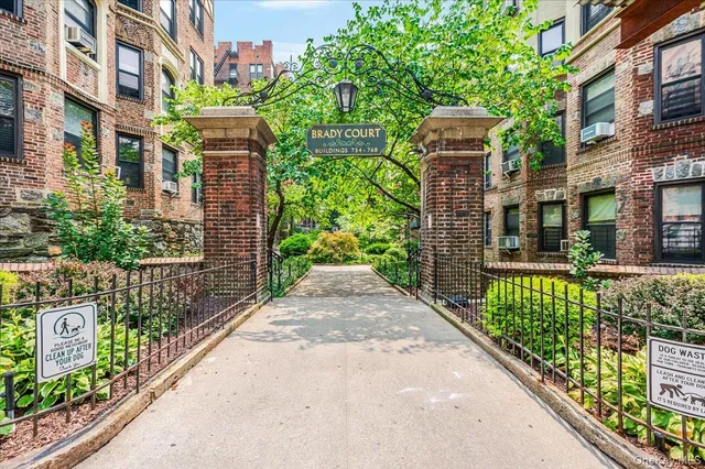 a pathway of a house with a small yard and potted plants