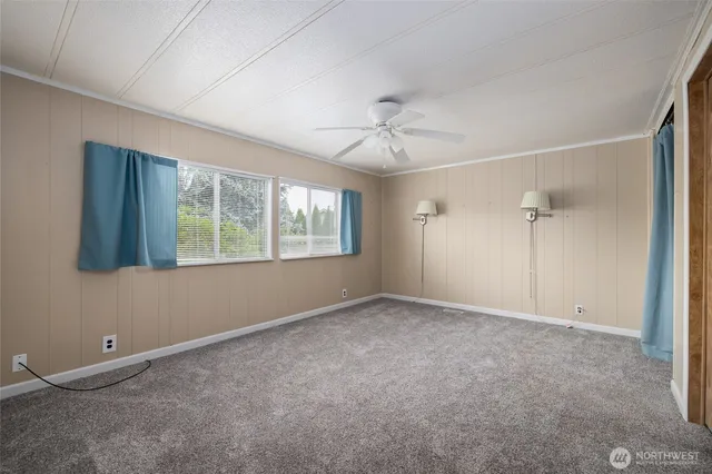 an empty room with chandelier fan and closet