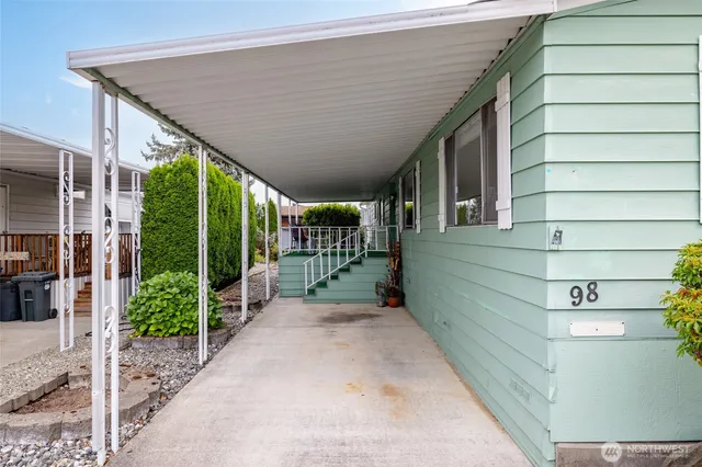 a porch with a table and chairs and potted plants