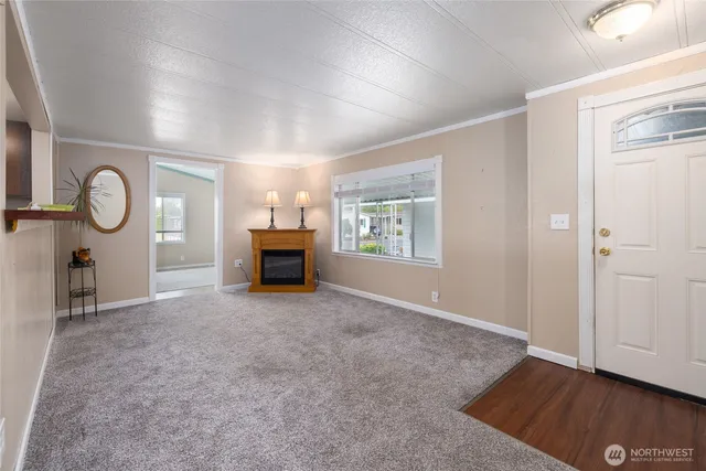 an empty room with windows and fireplace