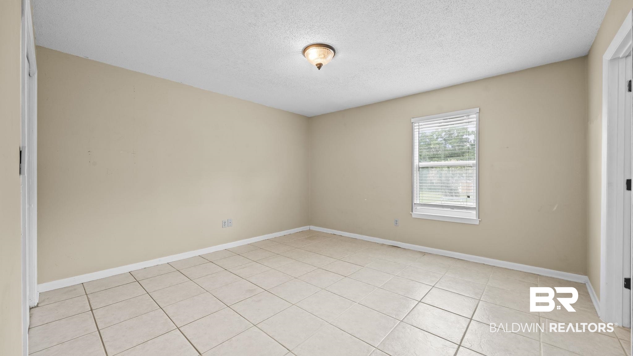 15096 Highland Circle Foley, AL 36535 - Photo 26 of 52 Spacious room featuring neutral-toned walls, tile flooring, a window with blinds, and a ceiling-mounted light fixture